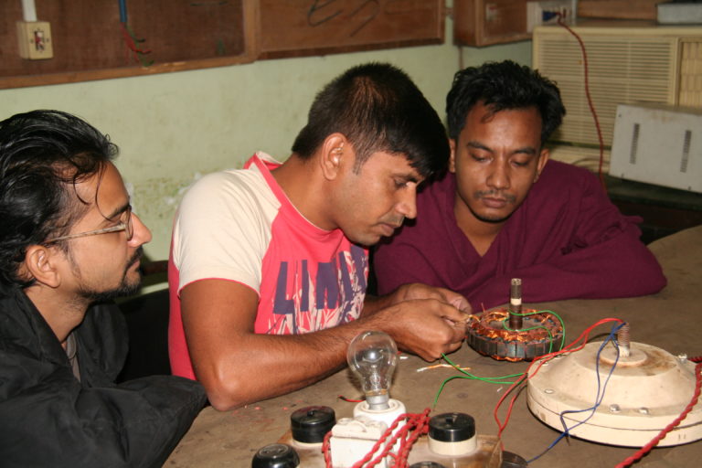 Drei Männer in Bangladesch lernen, elektrische Motoren zu bauen.