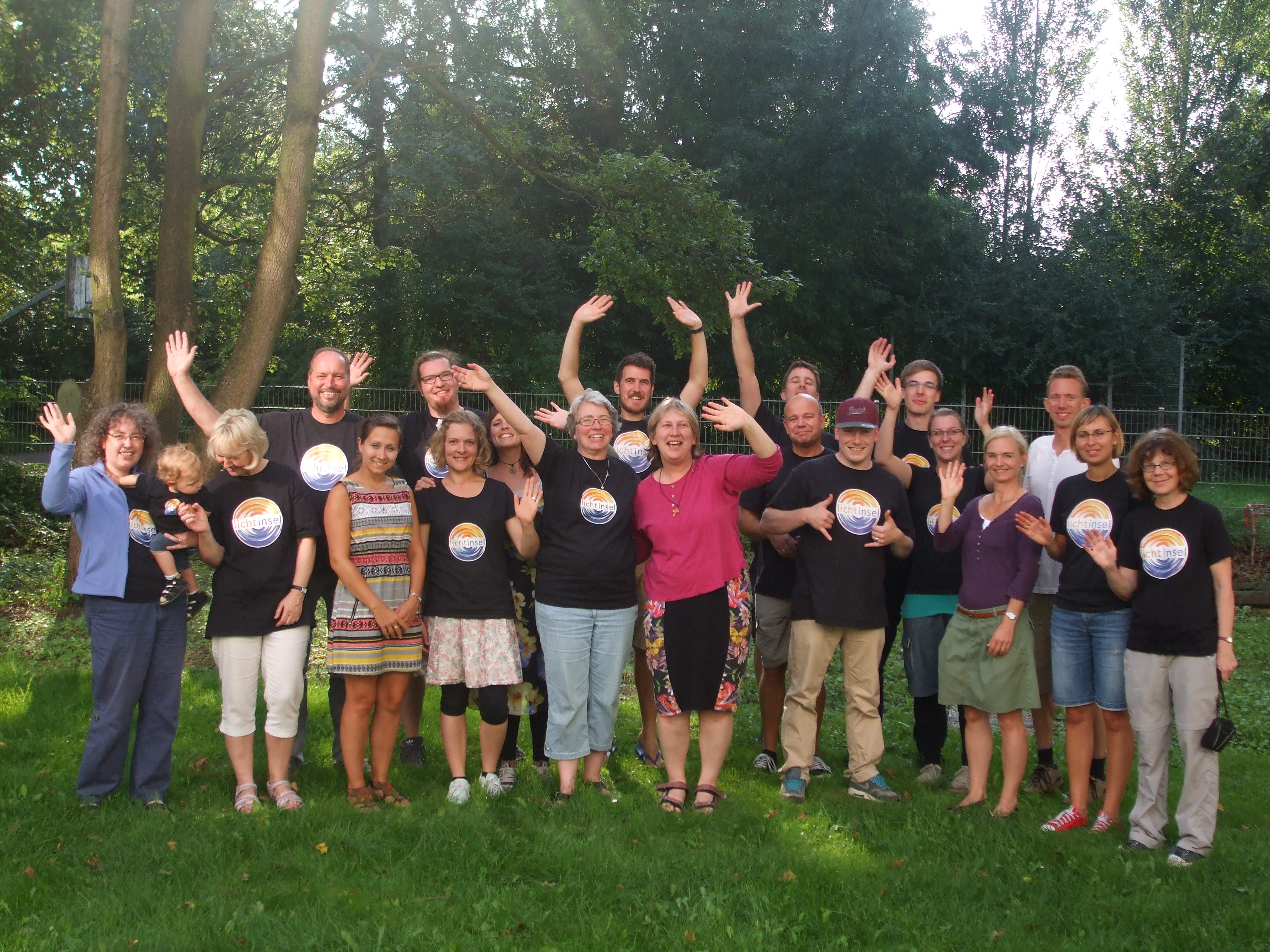 Gruppenbild, auf dem die Menschen winken